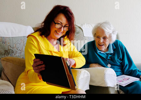 Una donna anziana con sua figlia matura utilizzando un ipad - Giovanni Gollop Foto Stock