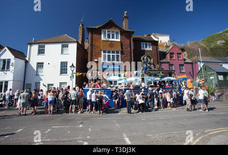 Festaioli di bere al di fuori del Dolphin Inn pub in una giornata di sole durante il martinetto sul Verde maggio giorno festivo, Hastings, East Sussex, Regno Unito Foto Stock