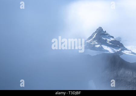 Poco Tahoma Peak osservata attraverso una fitta nebbia da lungo il Sentiero delle meraviglie. Il Parco Nazionale del Monte Rainier a Washington. Foto Stock