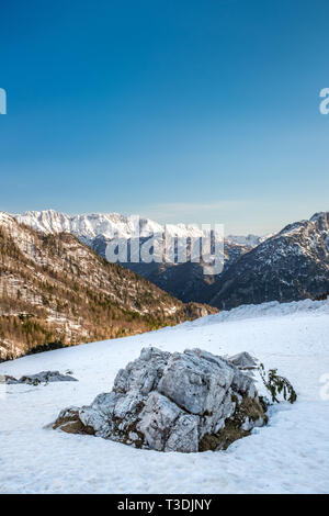 Vista dal campo nevoso con una roccia sul pass road Vrsic a. montagne Veliko Spicje, Trentski Pelc Srebrnjak e nel Parco Nazionale del Triglav nelle Alpi Giulie Foto Stock