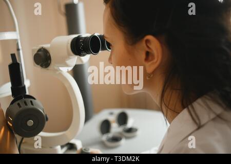 Femmina attraente medico oculista è il controllo della visione dell'occhio del paziente in clinica moderna. Foto Stock