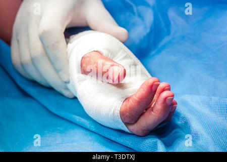 Chirurgo del bendaggio della mano di un paziente alla fine della chirurgia Foto Stock