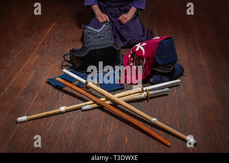 Guanti di Kendo, casco e la spada di bambù su una superficie di legno. Kendo armor. Foto Stock