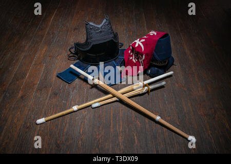 Guanti di Kendo, casco e la spada di bambù su una superficie di legno. Kendo armor. Foto Stock