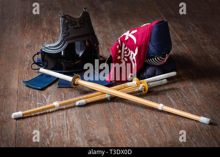 Guanti di Kendo, casco e la spada di bambù su una superficie di legno. Kendo armor. Foto Stock