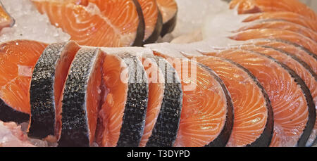 Salmone crudo su ghiaccio in un mercato del pesce Foto Stock