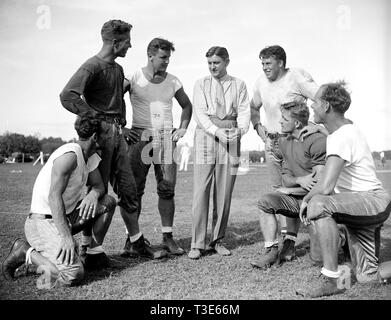 George Marshall, proprietario del Washington Redskins, colloqui con alcuni dei suoi giocatori, da sinistra a destra: Wayne Millner, affrontare, fine, Charlie Malone, fine. Vic Carroll, affrontare,. George Marshall, Bill giovani, affrontare, ed Michaels, Guardia, Jim Garber, affrontare Foto Stock