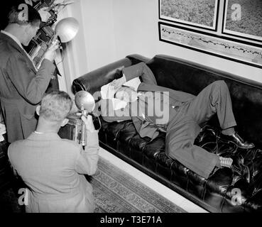 Il senatore Allen Ellender democratici di Louisana e onetime tenente del tardo Huey Long, è scattato dalla news cameramen come egli si appoggia nel suo ufficio di ca. 1938 Foto Stock