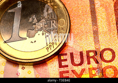 1 Euro moneta su un 10 Euro nota Foto Stock