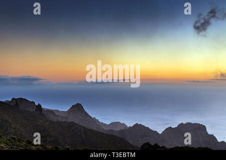 Spia arancione nel cielo sopra il mare e le creste in Teno Masif visto dalla Degollada del Cherfe, Masca, Tenerife, Isole Canarie, Spagna Foto Stock