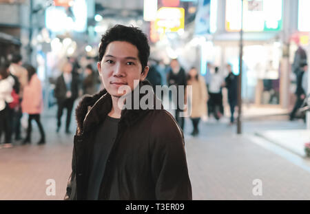 Attraente giovane uomo sulla strada pedonale in Shibuya, Tokyo Giappone Foto Stock