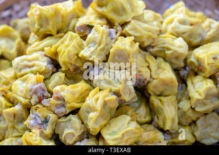 Dimsum cotti al vapore in bambù a street market alimentare in Thailandia, vicino. Dim sum di un piatto cinese di piccole al vapore o fritte gnocchi di salato contenente var Foto Stock