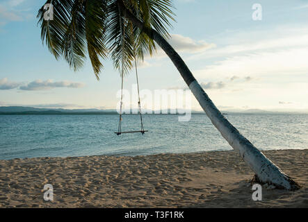 Spiaggia swing attaccato a un albero di palma in ambienti tropicali. RF off-season concetto di viaggio. Isole San Blas, Panama America centrale. Ott 2018 Foto Stock