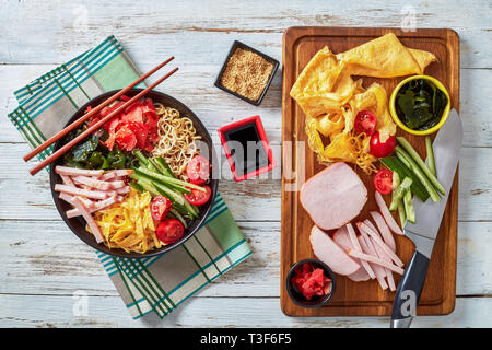 Vista aerea del Hiyashi chuka, freddo ramen insalata estiva - refrigerati egg noodles e rabboccato con il cetriolo, alghe, decapati red ginger - beni shoga, strisce Foto Stock