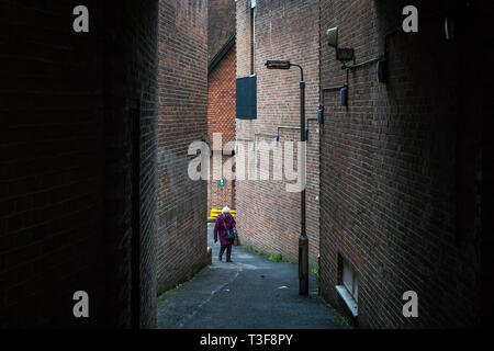 Reigate, Regno Unito - 23 Gennaio 2019 - una vecchia donna a camminare su una strada Foto Stock