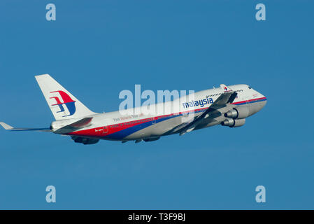 Malaysia Airlines Boeing 747 Jumbo Jet aereo di linea 9M-MPH decolla dall'aeroporto di Londra Heathrow, Londra, Regno Unito in cielo blu Foto Stock