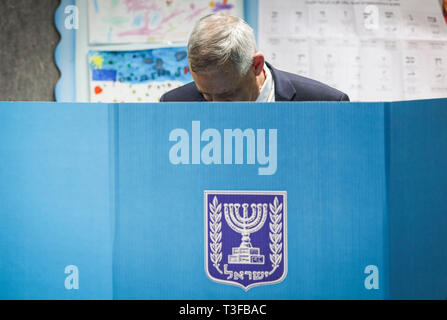 Rosh Ha Ayin, Israele. 09Apr, 2019. Benny Gants, la testina del blu e del bianco alleanza politico, sorge dietro un voto di booth come Egli getta il suo voto per il popolo israeliano elezioni generali. Credito: Ilia Yefimovich/dpa/Alamy Live News Foto Stock