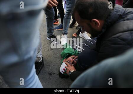 Algeri, Algeria. 09Apr, 2019. Un manifestante tende ad uno studente ferito durante gli scontri tra manifestanti e sicurezza froces durante un governo anti-demonstraion. Il Parlamento algerino ha dichiarato il posto vacante di presidente di post e altoparlante denominato Abdelkader Bensalah a condurre in Algeria per un periodo transitorio di novanta giorni fino alla elezione del successore del rassegnato le dimissioni il Presidente Abdelaziz Bouteflika. Credito: Farouk Batiche/dpa/Alamy Live News Foto Stock