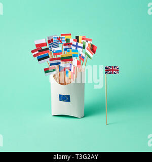 Diverse bandiere di carta in una scatola di cartone con un segno dell'UE e la bandiera della Gran Bretagna a parte su uno sfondo verde . L'uscita della Gran Bretagna dall UE Foto Stock