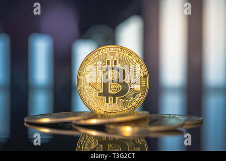 Golden bitcoin sono impilati su uno sfondo di grafici aziendali close-up. Foto Stock