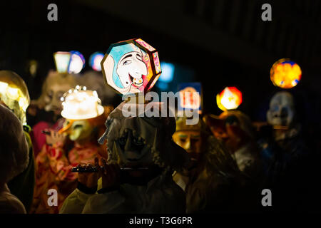 Marktgasse, Basilea, Svizzera - Marzo 11th, 2019. Close-up di piccolo giocatori nei loro singoli costumi di carnevale con testa illuminata lanterne. Foto Stock