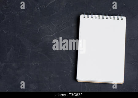 Blank notepad foglio su di una superficie scura. Nizza mock up per i progettisti di opere d'arte. Foto Stock