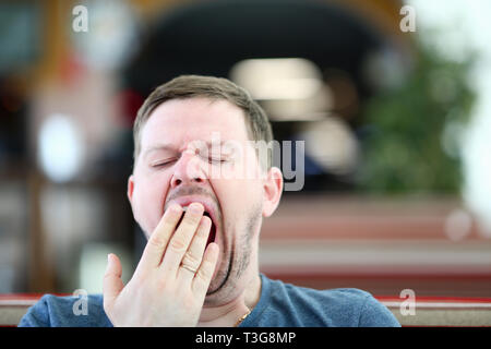 Giovane uomo attraente sbadigli in cafe la copertura Foto Stock