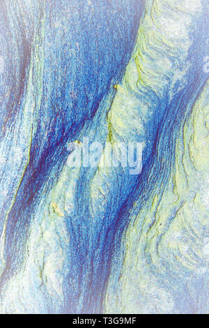 Abstract blu, grigio, arancione e sfondo verde - strati di rocce esposte da mare in Northumberland Foto Stock