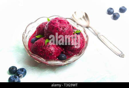 Mirtillo frutta gelato in una tazza isolata su bianco Foto Stock