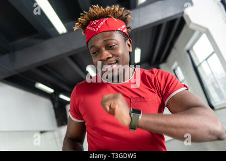 Ben conformato montare l uomo indossa t-shirt rossa e grigio sneakers Foto Stock