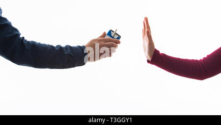 Giovane donna che rifiuta di prendere la sigaretta dal pacchetto. Femmina che mostra un segno di stop con la mano per sigarette. Smettere di fumare concetto. Foto Stock