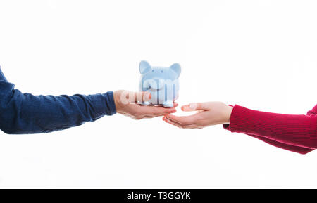 Man mano dando salvadanaio per la giovane donna su sfondo bianco. Investimenti, piano di risparmio e il concetto di trust. Foto Stock