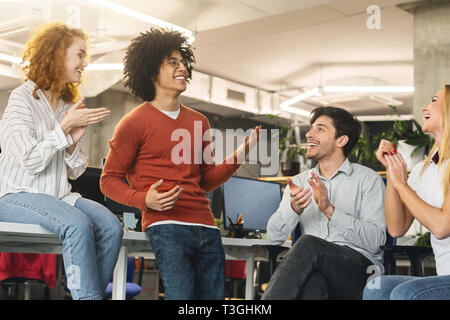 Allegro team aziendale saluto il loro collega di successo Foto Stock