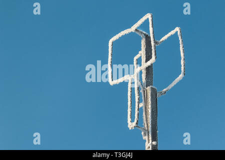 Self-made antenna televisiva di filo di alluminio contro un cielo blu nel gelo invernale ricoperta di brina e neve Foto Stock