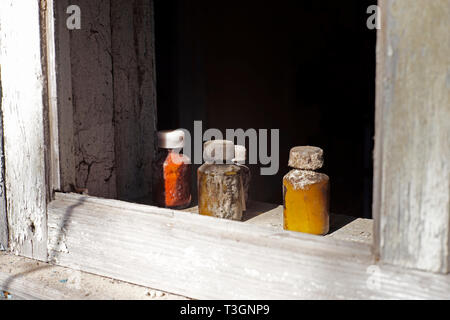 Bottiglie di medicina nella finestra di un antico ambulatorio medico nel villaggio di Zalissia, all'interno della centrale di Cernobil zona di esclusione Foto Stock