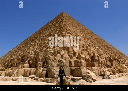 Poliziotto egiziano in piedi di fronte a una piramide del Cairo in Egitto. Foto Stock