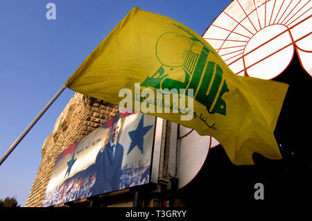 Bandiera di Hezbollah e un poster di Bashar Al Assad a Hamadiyya souk in Damasco, Siria. Foto Stock