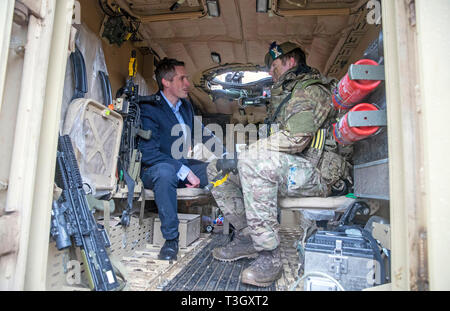 Il Segretario della Difesa Gavin Williamson (sinistra) parla di Cpl Wayne Fiddler in un Mastiff veicolo durante una visita di Salisbury Plains Area Formazione, dove ha annunciato il Regno Unito il piano di aprire un centro di eccellenza per la sicurezza umana. Foto Stock