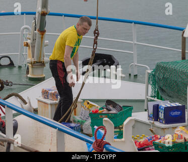 Trawler equipaggio re il provisioning o il ripopolamento di memorizzazione alimentare nave. Foto Stock