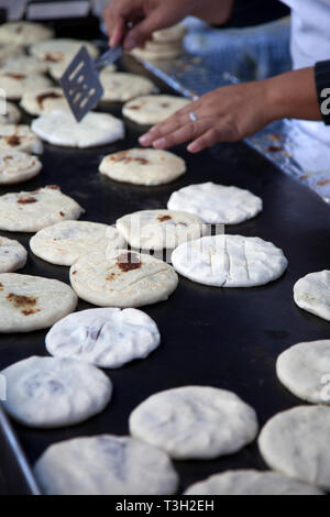 Pupusas, una tipica strada di El Salvador il cibo proveniente da mais, essendo cotti su una strada laterale comal in El Salvador, Foto Stock