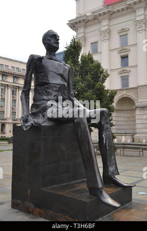 Mano e uomo rotto statua in bronzo di 'Iuliu Maniu' nella Piazza della Rivoluzione del Comitato Centrale del Partito Comunista edificio dietro, Bucarest Romania Foto Stock