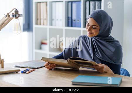 Donna positiva assorbita nella lettura Foto Stock