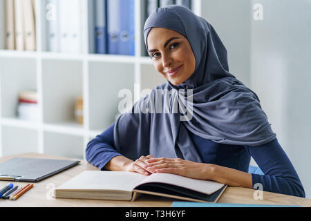 Insegnante femmina seduto alla scrivania Foto Stock