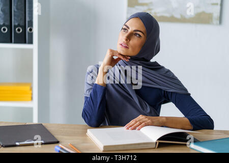 Donna musulmana Interrogandosi circa Foto Stock