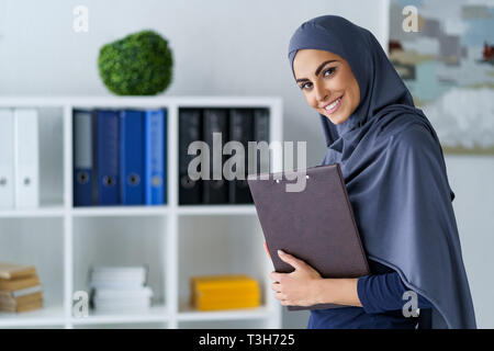 Donna sorridente in ufficio Foto Stock