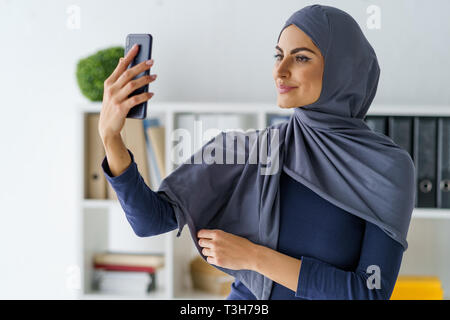 Arabian donna prendendo un selfie Foto Stock