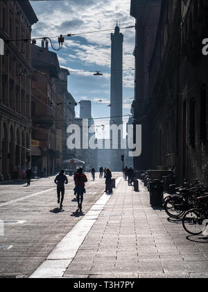 Domenica mattina delle guide di scorrimento nel centro di Bologna con le Torri Gemelle, Torre della Garisenda e la Torre degli Asinelli nella distanza. Foto Stock