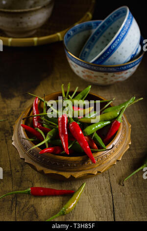 Thai rosso e verde o chilis Prik Chee fah talvolta anche noto come Birds Eye peperoncino peperoni fiery con potenza nominale di 50.000 a 100.000 unità scoville Foto Stock