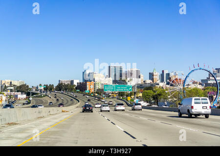 Marzo 31, 2019 Oakland / CA / STATI UNITI D'AMERICA - Viaggiare in autostrada a est di San Francisco Bay Area; lo skyline di Oakland's downtown visibile sul lato destro Foto Stock