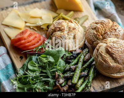 Cotto al forno funghi champignon burger con aggiunta di lattuga fresca, pomodoro, asparagi e fresche foglie di spinaci Foto Stock